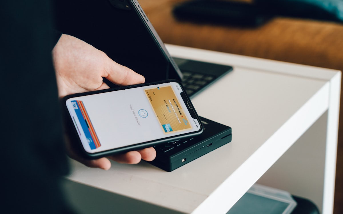 Payment & Renewal Reminders voice AI for edtech — A person paying with a mobile wallet on a phone